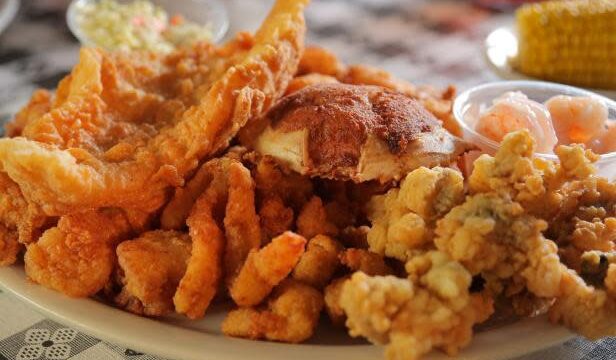 Fried shrimps on a white plate sitting on a black and white tablecloth