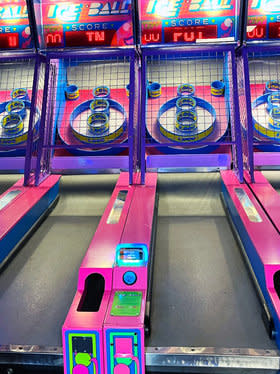 A pink and purple skee ball machine