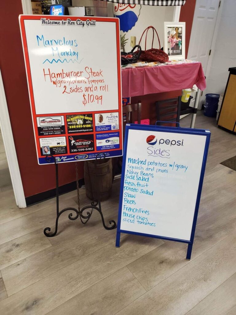 Two white boards list daily specials and beverages at a restaurant